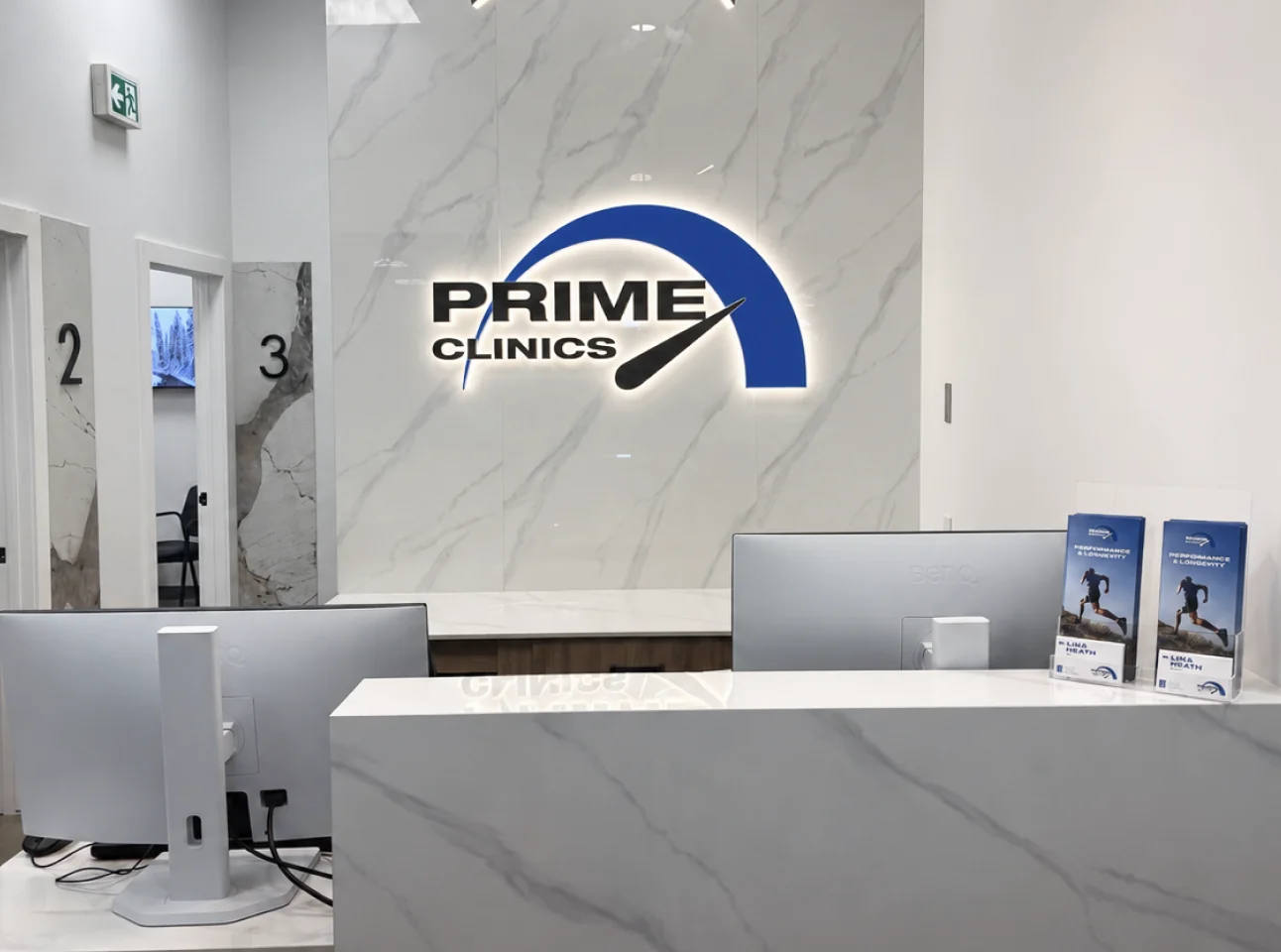 The Prime Clinics reception desk with the illuminated Prime Clinics sign